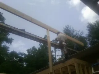 Carpenter setting a ridge beam over a new addition frame — Ice Dam Removal by Roofing Brothers in Leadville