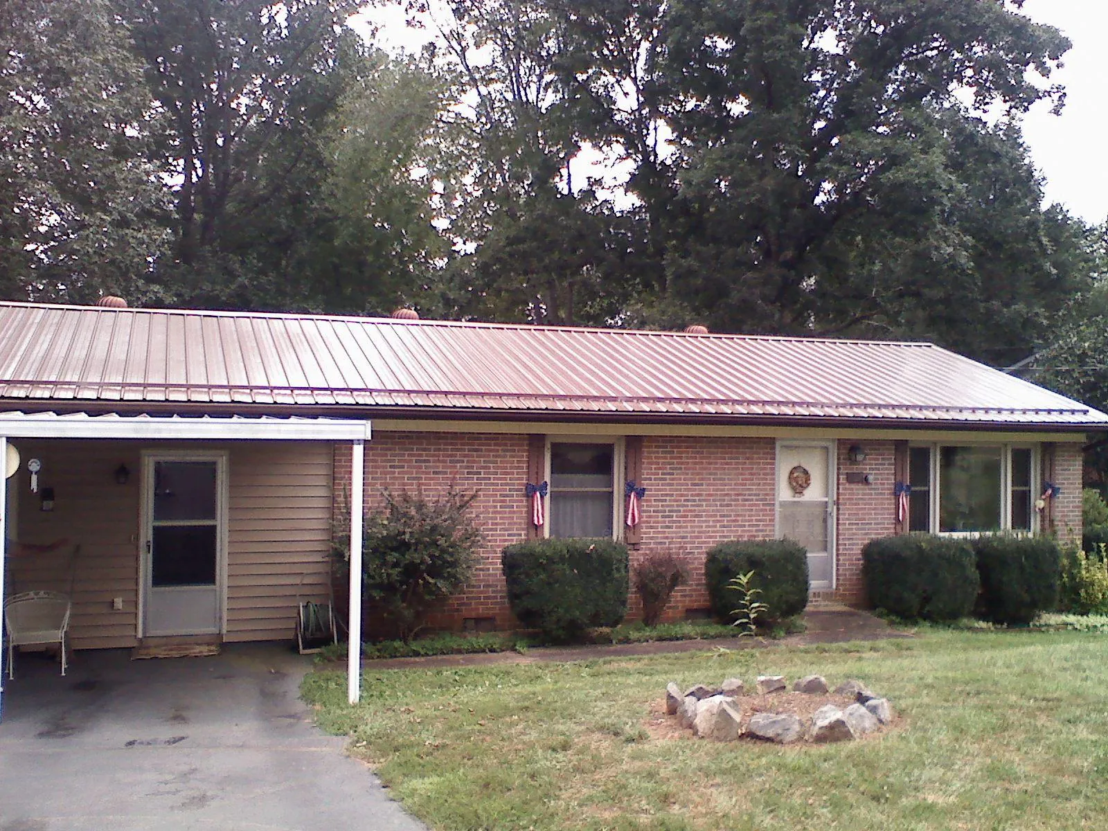 Bronze metal roof and carport on a brick ranch home — Roof Repair work by our crew in Leadville